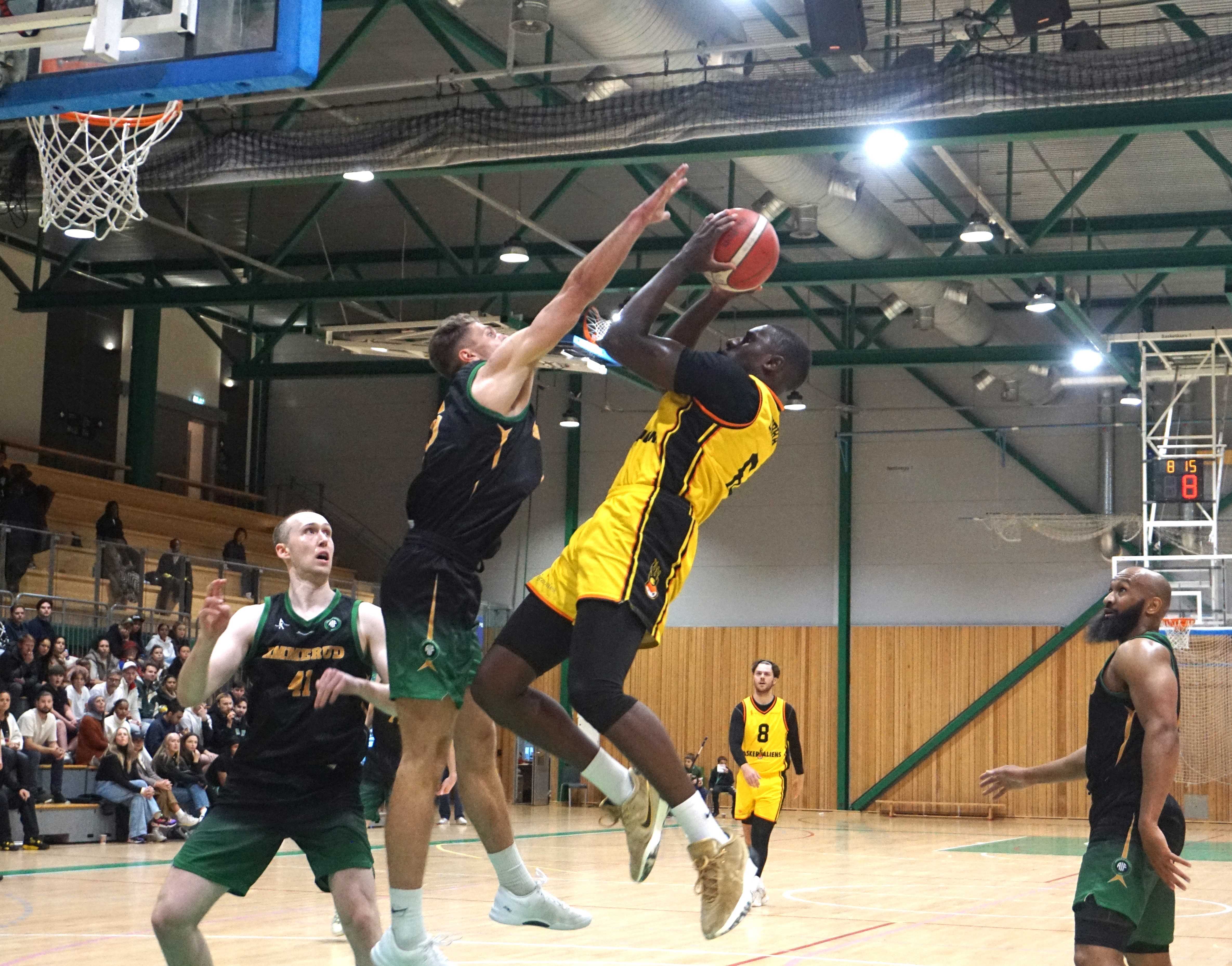 Mustapha Dibba var overalt i åpningsminuttene mot sine tidligere lagkamerater og sto med 9 poeng da Asker ledet 22-12 og før han måtte ut med skade. Her får den svenske forwarden kjempet seg til et skudd over Mikal Gjerde. Til venstre i bildet er Henrik Male Davidsen, til høyre Eric Gilchrese.
FOTO: ARILD SANDVEN 