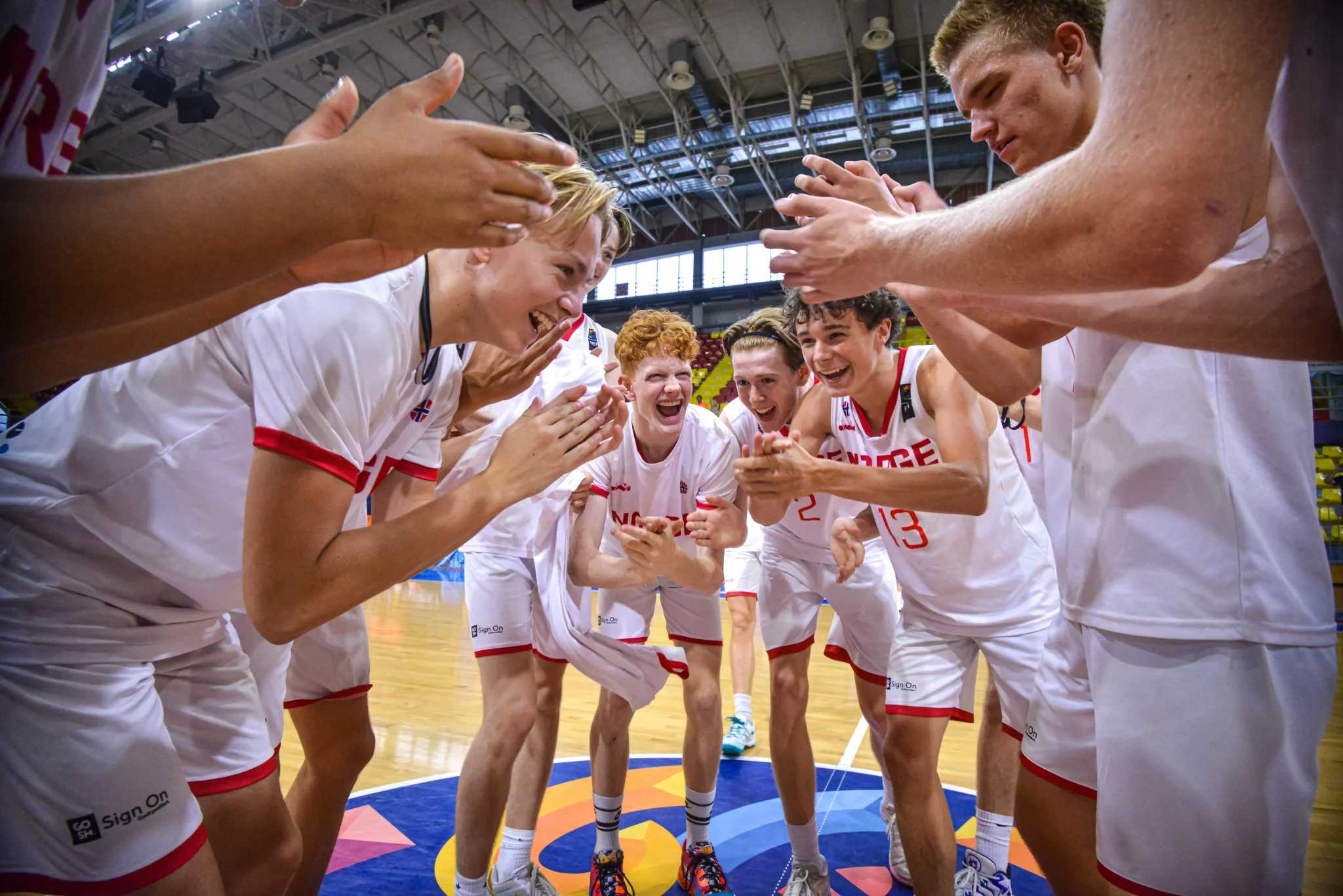 U16-spillerne jubler for en ny seier, denne gang 87-66 over Ukraina. Vi ser William Dronsett til venstre, Jakob Ellingsen (delvis skjult), Mio Mandt, Edvard Orskaug, William Rødsten Kristiansen og Viktor Brovold-Kühn.
FOTO: FIBA.COM 